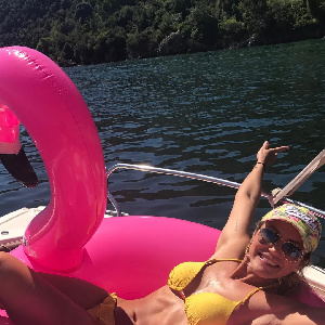 Frau im gelben Bikini auf rosa Schwimmpelikan